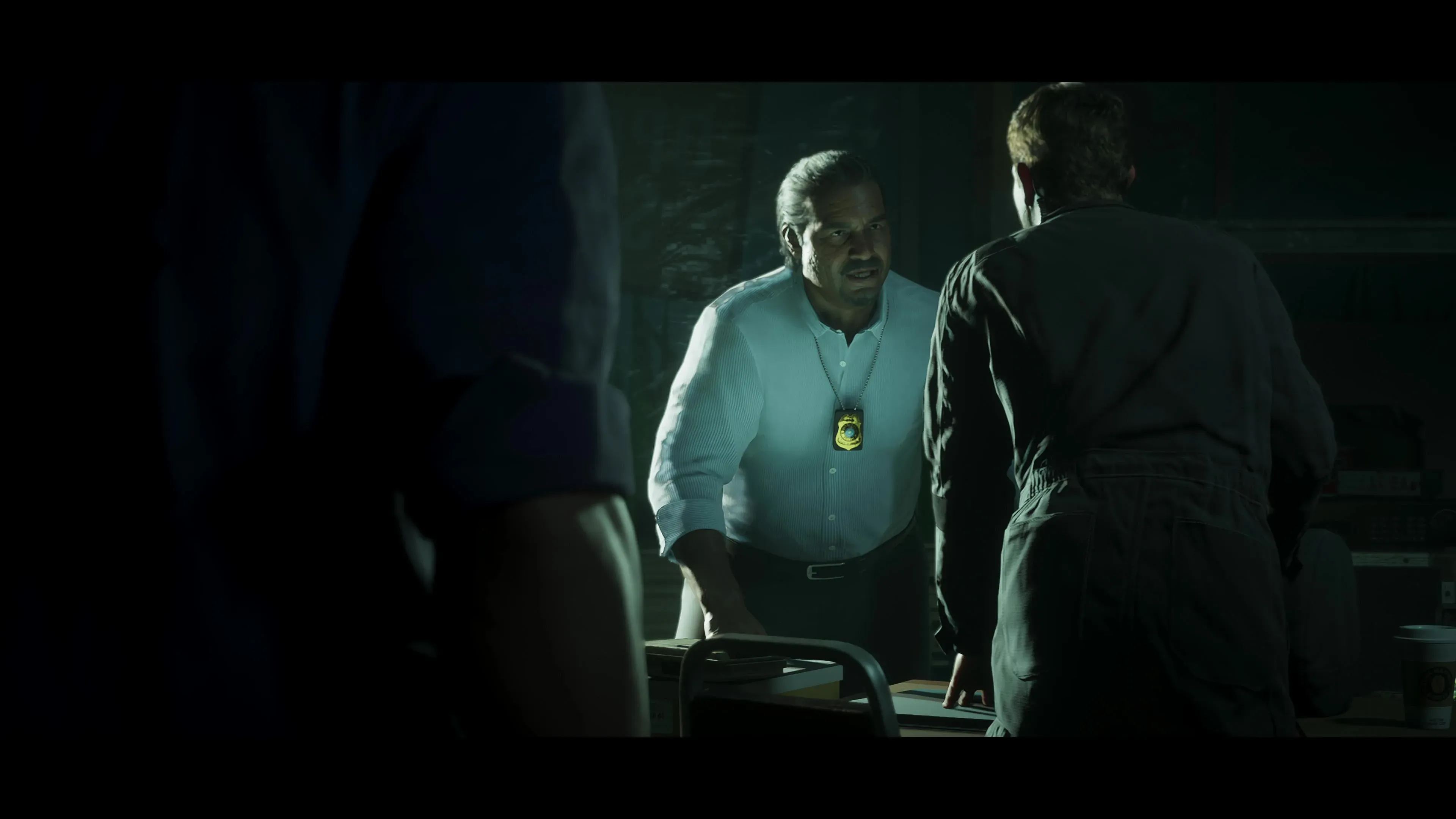 Mendez wearing a badge in a dimly lit room in GTA 6 Trailer 2.